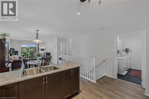 Kitchen island with double stainless steel sink and granite-look countertop - 51 Millcroft Drive, Simcoe, ON - Indoor Photo Showing Kitchen With Double Sink