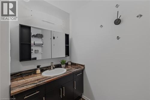 Vanity with an oval undermount sink, a chrome faucet, and a patterned countertop - 51 Millcroft Drive, Simcoe, ON - Indoor Photo Showing Bathroom