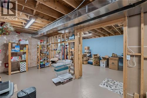 Unfinished basement space featuring exposed wooden joists, concrete flooring, fluorescent lighting, and partially framed walls - 51 Millcroft Drive, Simcoe, ON - Indoor Photo Showing Basement
