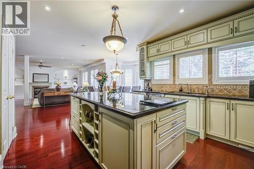 Gourmet kitchen featuring an expansive center island with built-in storage, dark stone countertops, and custom cabinetry - 4278 Clubview Drive, Burlington, ON - Indoor Photo Showing Kitchen With Upgraded Kitchen