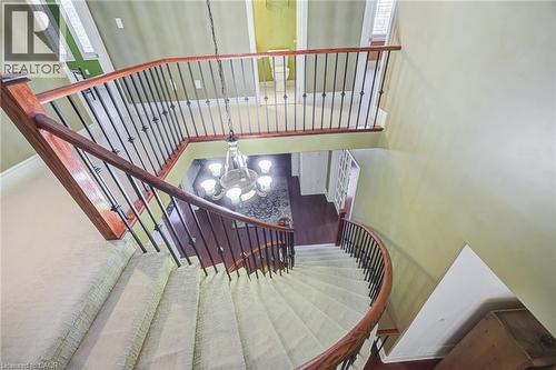 Carpeted spiral staircase with dark wood handrails and wrought iron balusters - 4278 Clubview Drive, Burlington, ON - Indoor Photo Showing Other Room