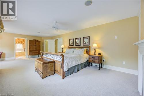 Spacious carpeted room featuring a ceiling fan, crown molding, and a visible portion of a fireplace mantel - 4278 Clubview Drive, Burlington, ON - Indoor Photo Showing Bedroom