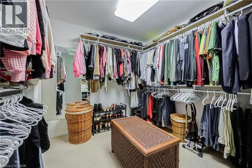 Walk-in closet featuring extensive built-in shelving, multiple hanging rods, recessed lighting, and soft carpet flooring - 4278 Clubview Drive, Burlington, ON - Indoor With Storage