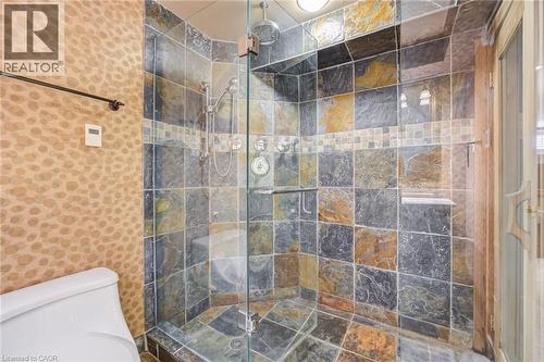 Walk-in shower featuring multi-toned slate tile, a glass enclosure, and a built-in shower bench - 4278 Clubview Drive, Burlington, ON - Indoor Photo Showing Bathroom