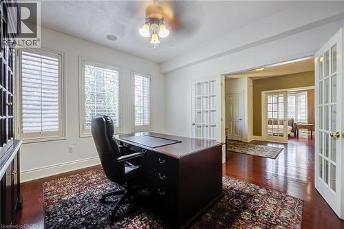 Room featuring rich wood-finish flooring, three windows with plantation shutters, and a ceiling fan with integrated lighting - 4278 Clubview Drive, Burlington, ON - Indoor Photo Showing Office