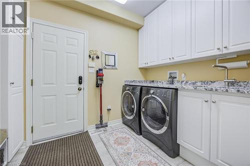 Laundry area featuring white cabinetry, a light-toned countertop, and a utility sink - 4278 Clubview Drive, Burlington, ON - Indoor Photo Showing Laundry Room