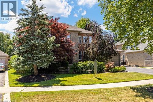 Stone facade residence featuring a front lawn with mature trees and established landscaping - 4278 Clubview Drive, Burlington, ON - Outdoor