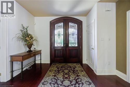 Grand entryway featuring dark wood double doors with intricate wrought iron and clear glass inserts - 4278 Clubview Drive, Burlington, ON - Indoor Photo Showing Other Room