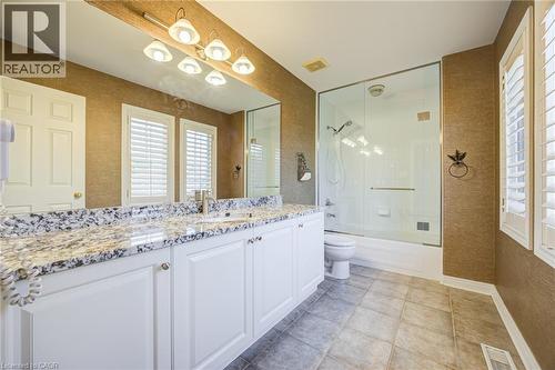 Bathroom featuring a double vanity with a patterned countertop, white cabinetry, and dual sinks - 4278 Clubview Drive, Burlington, ON - Indoor Photo Showing Bathroom