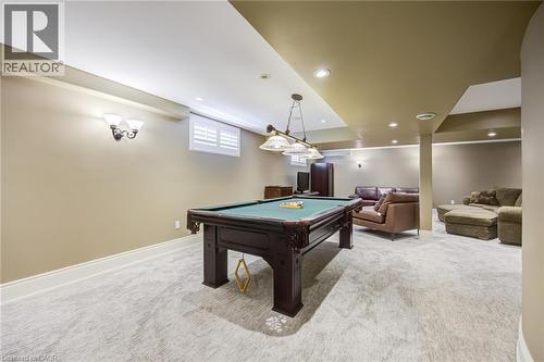 Finished basement featuring recessed lighting, a window with white louvered shutters, light-toned carpet flooring, and a decorative wall sconce - 4278 Clubview Drive, Burlington, ON - Indoor Photo Showing Other Room