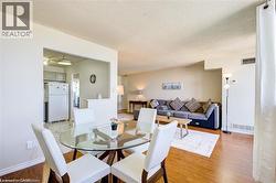 Open-concept living space featuring wood-finish flooring, a kitchen pass-through, and neutral wall tones - 
