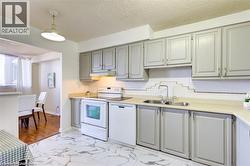 Kitchen featuring gray cabinetry, a double basin stainless steel sink, and white appliances - 