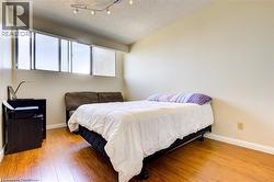 Room with wood-finish flooring, a neutral wall color, and white baseboards - 