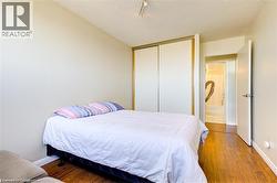 Bedroom featuring wood-finish flooring, neutral wall paint, and a textured ceiling - 