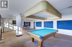 Recreational room featuring a billiards table, patterned carpet, wall-mounted dartboard, and multiple display boards - 