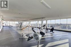 Expansive fitness center featuring a rubberized floor, full-height windows, and recessed lighting - 