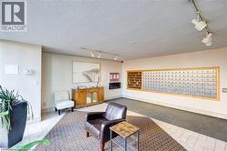 Inviting common area featuring a mix of tile and carpet flooring, a large mail center with individual boxes, and track lighting - 