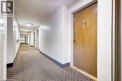 Hallway featuring patterned carpet flooring, white walls, and flush-mount ceiling lights - 
