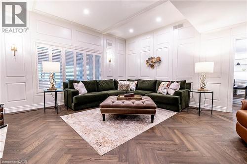 Spacious living area featuring wood-finish herringbone flooring and extensive panel molding - 76 Adriatic Boulevard, Hamilton, ON - Indoor
