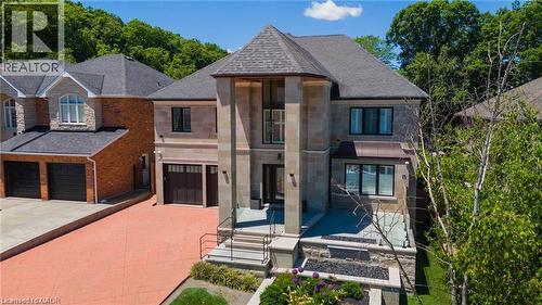 Contemporary-style home featuring stone and brick facade, a prominent front entrance with tall columns, and a multi-level roofline - 76 Adriatic Boulevard, Hamilton, ON - Outdoor