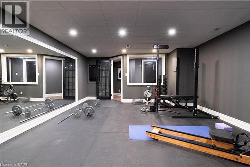 Dedicated fitness room featuring rubber flooring, recessed lighting, expansive wall mirror, and dual French-style doors - 76 Adriatic Boulevard, Hamilton, ON - Indoor Photo Showing Gym Room