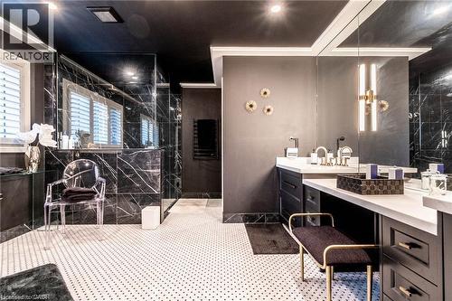 Bathroom featuring black marble-look wall tiling, a custom vanity with dual sinks, white countertop, and a built-in shower with glass enclosure - 76 Adriatic Boulevard, Hamilton, ON - Indoor Photo Showing Bathroom