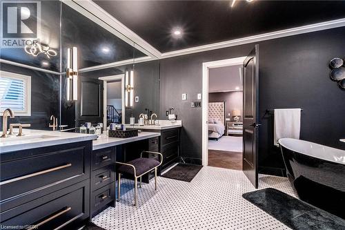 Modern bathroom featuring a freestanding black tub, dual vanities with white countertops, and contemporary wall-mounted lighting - 76 Adriatic Boulevard, Hamilton, ON - Indoor Photo Showing Bathroom