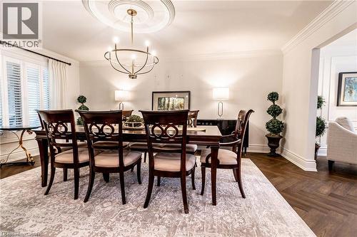 Dining area featuring herringbone wood-finish flooring, an ornate ceiling medallion, and a chandelier - 76 Adriatic Boulevard, Hamilton, ON - Indoor Photo Showing Dining Room
