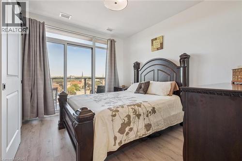 Bright bedroom featuring full-height sliding glass door leading to a balcony - 15 Glebe Street Unit# 902, Cambridge, ON - Indoor Photo Showing Bedroom