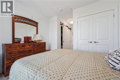 Bedroom space featuring bright white walls, contemporary white double panel doors, and a barn door leading to an additional area - 15 Glebe Street Unit# 902, Cambridge, ON - Indoor Photo Showing Bedroom