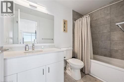 Bathroom featuring a white vanity with an integrated sink, polished chrome faucet, and expansive mirror with overhead lighting - 15 Glebe Street Unit# 902, Cambridge, ON - Indoor Photo Showing Bathroom