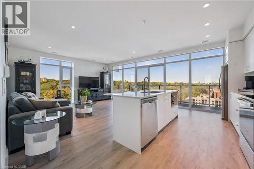 Open concept living area with expansive floor-to-ceiling windows, light wood-finish flooring, and recessed lighting - 15 Glebe Street Unit# 902, Cambridge, ON - Indoor Photo Showing Kitchen With Upgraded Kitchen