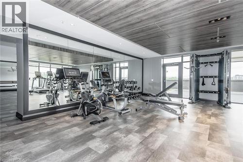 Fitness center featuring wood-finish flooring, a full-wall mirror, and full-height windows - 15 Glebe Street Unit# 902, Cambridge, ON - Indoor Photo Showing Gym Room