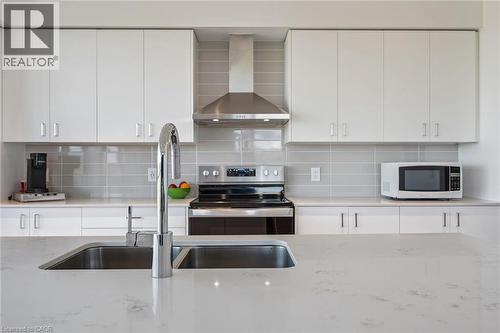 Contemporary kitchen featuring white cabinetry and light-toned countertops - 15 Glebe Street Unit# 902, Cambridge, ON - Indoor Photo Showing Kitchen With Stainless Steel Kitchen With Double Sink With Upgraded Kitchen