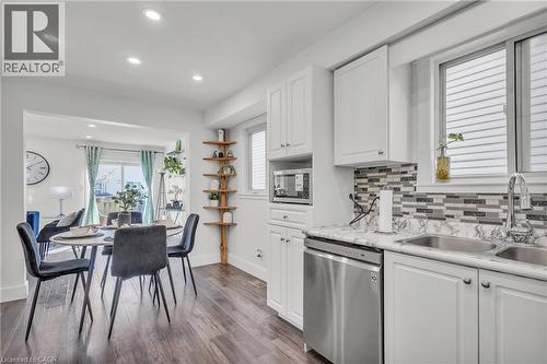 Modern kitchen featuring white cabinetry, stainless steel appliances, a mosaic tile backsplash, and a double basin sink - 425 Erinbrook Drive, Kitchener, ON - Indoor Photo Showing Kitchen With Double Sink With Upgraded Kitchen
