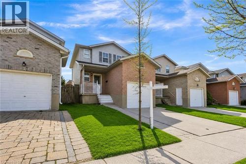 Two-story residence featuring a brick facade with light gray siding, an attached garage, and a covered front porch with white railings - 425 Erinbrook Drive, Kitchener, ON - Outdoor With Facade