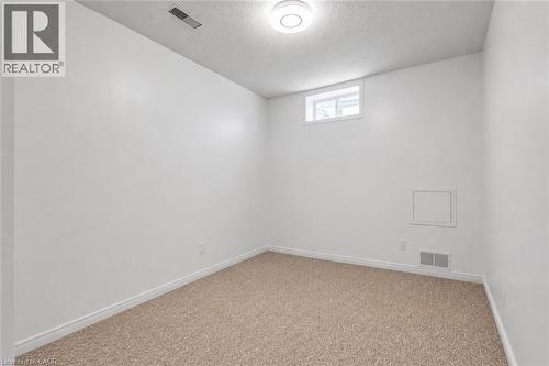 Carpeted room featuring white painted walls, a flush-mount ceiling light fixture, a high-set window, and baseboard trim - 425 Erinbrook Drive, Kitchener, ON - Indoor Photo Showing Other Room