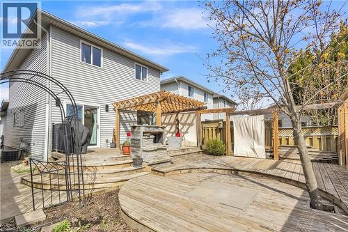 Multi-level wood deck featuring a built-in stone outdoor fireplace, a wooden pergola, and a privacy screen - 425 Erinbrook Drive, Kitchener, ON - Outdoor With Deck Patio Veranda