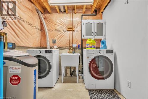 Dedicated laundry area featuring a utility sink, upper cabinetry, and exposed ceiling joists - 425 Erinbrook Drive, Kitchener, ON - Indoor Photo Showing Laundry Room