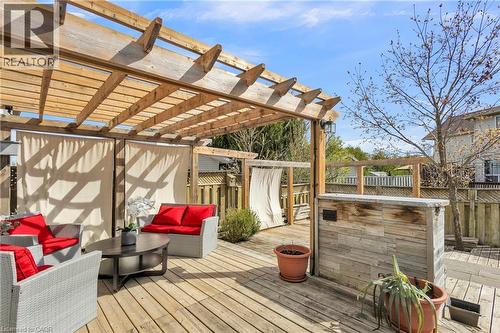 Expansive wood deck featuring a large pergola, privacy screens, and a built-in bar with stone-look paneling - 425 Erinbrook Drive, Kitchener, ON - Outdoor With Deck Patio Veranda
