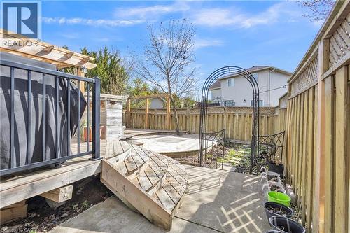 Expansive backyard featuring a multi-level wood deck, a concrete patio area, and a wood privacy fence - 425 Erinbrook Drive, Kitchener, ON - Outdoor With Deck Patio Veranda