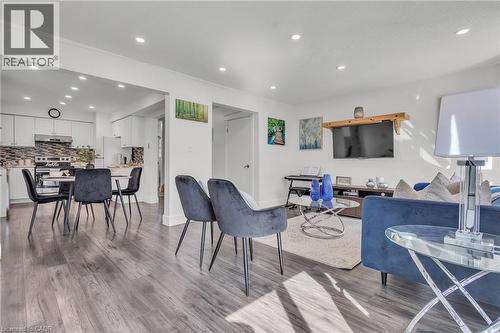 Open concept living space featuring wood-finish flooring, recessed lighting, a dining area, and a kitchen with white cabinetry and a patterned backsplash - 425 Erinbrook Drive, Kitchener, ON - Indoor