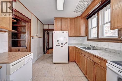 Kitchen featuring wood cabinetry, a dual basin sink, and tile flooring - 147 Courtland Avenue E, Kitchener, ON - Indoor Photo Showing Kitchen With Double Sink