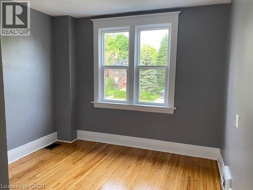 Hardwood flooring complemented by gray walls and white trim - 1066 Richmond Street, London, ON - Indoor Photo Showing Other Room