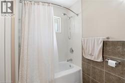 Full-size bathtub with white subway tile surround and a chrome showerhead - 