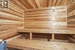 Custom wood-paneled sauna featuring a multi-tiered bench design - 