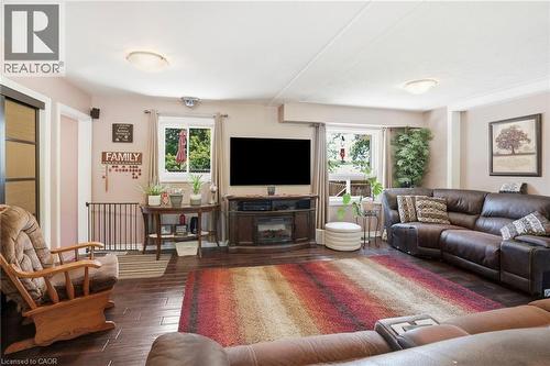 Spacious living area featuring dark wood-finish flooring and ample natural light from two windows - 25 Saveryn Road, Hamilton, ON - Indoor Photo Showing Living Room