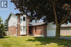 Brick and siding two-story residence featuring a prominent bay window - 