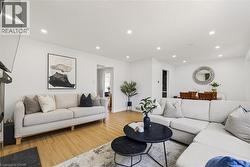 Open-concept living space featuring wood-finish flooring and recessed lighting - 