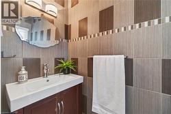 Contemporary bathroom vanity featuring a rectangular integrated sink, chrome faucet, and dark wood-finish cabinetry - 